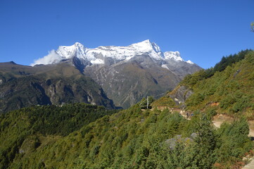 Hiking in the stunning Khumbu Valley surrounded by glaciars and snowy peaks in the Himalayan Everest Base Camp Trek
