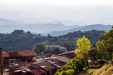 Cityscape of Manizales, Caldas, Colombia. Evening light. Green forest background. Aerial panorama.