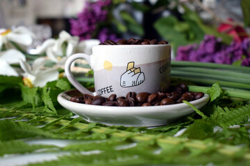 Daffodils bloom from March to June. The flower consists of six white petals. Coffee beans on the table in a cup