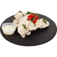 Boiled pork tenderloin with tomatoes and white sauce on a plate on a white background