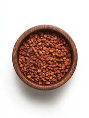 Fototapeta premium Top down view of a wooden bowl filled with dried apricots isolated against a white background.