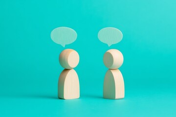Two Wooden Figurines in Conversation Against Teal Background