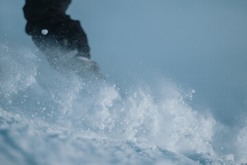 A dynamic and energetic image of a snowboarder plowing through snow in motion, capturing an...