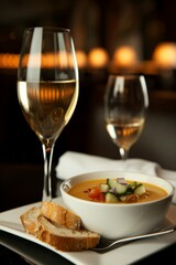Gazpacho: A chilled bowl of tomato-based soup with a smooth texture, garnished with diced cucumber, onion, green bell peppers, and a drizzle of olive oil.