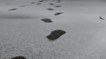Footprints of a person on the surface of snowy courtyard in
winter.