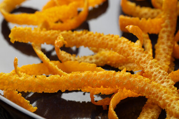 Pile of fresh orange zest on plate, closeup
