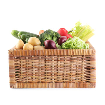 Different ripe vegetables in wicker box isolated on white