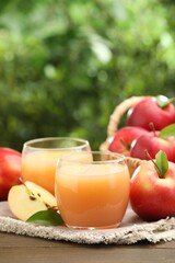 Tasty apple juice and fresh fruits on wooden table against blurred background, closeup