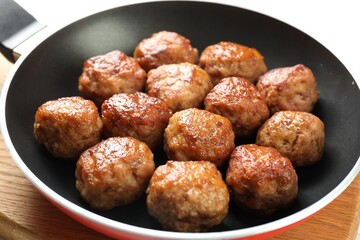 Tasty meatballs in frying pan on white table, closeup