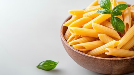 Delicious penne pasta in a wooden bowl on a white background