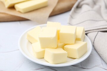 Pieces of fresh butter on white textured table, closeup