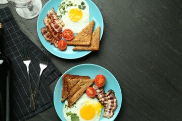 Tasty food and wine served for brunch on black table, flat lay. Space for text