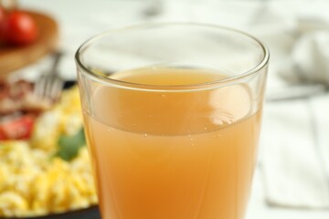 Glass of fresh apple juice and tasty brunch served on table, closeup