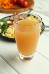 Tasty brunch. Glass of apple juice and scrambled eggs with bacon served on white wooden table, closeup