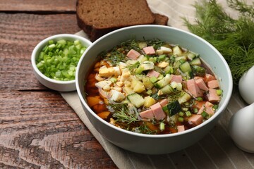 Delicious okroshka soup with kvass served on wooden table, closeup