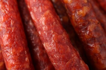 Different tasty smoked sausages as background, closeup