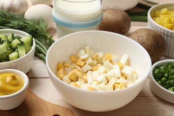 Fresh ingredients for okroshka soup on light wooden table, closeup