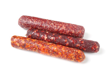 Many different dry cured sausages isolated on white