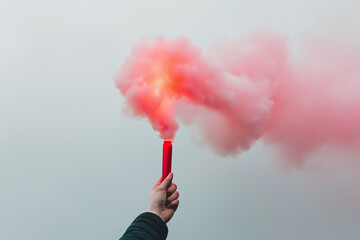 a hand holding a red smoke flare