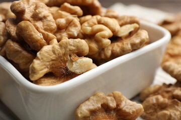 Peeled walnuts in bowl on table, closeup