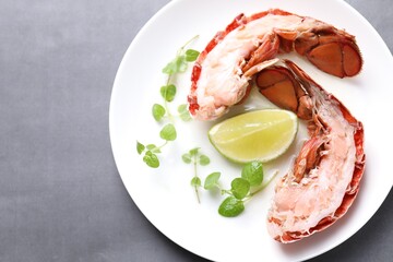 Delicious tail of boiled lobster served on grey table, top view