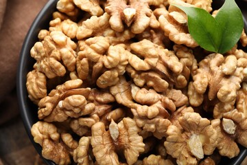 Fresh ripe walnuts in bowl on table, top view