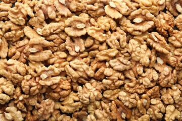 Pile of fresh ripe walnuts as background, top view