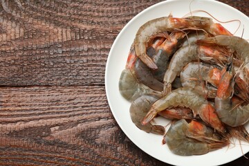 Fresh raw shrimps on wooden table, top view. Space for text