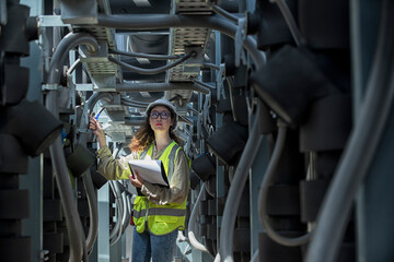 mechanic at work. Female engineer inspects and controls the cooling system of a large factory air...