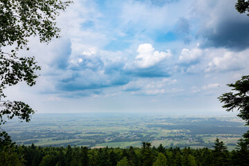 A Scenic Overlook Offering a Breathtaking View of a Lush Green Landscape Beneath a Cloudy Sky