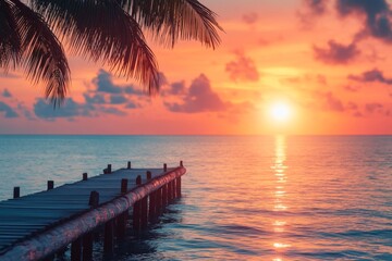 Fototapeta premium Vibrant sunset over calm ocean viewed from wooden pier in tropical location
