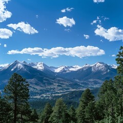 Obraz premium Majestic Mountain Range with Snow-Capped Peaks and Lush Green Valley under a Blue Sky