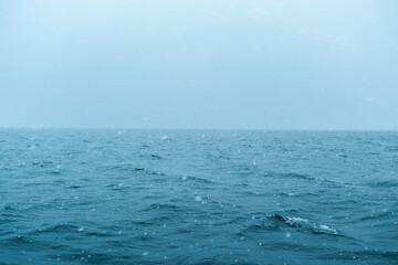 Choppy ocean waves under overcast sky during a rainy day
