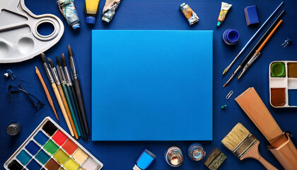 art supplies around blank squared blue canvas