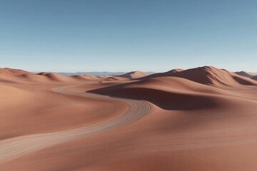 Naklejka premium Winding desert road through sand dunes under blue sky