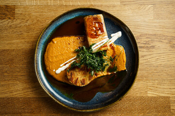 Gourmet dish with savory pastry, sauce, and grilled vegetables