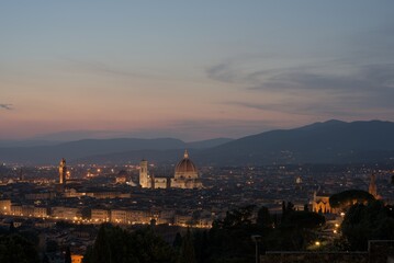 Obraz premium Florence illuminated by vibrant fireworks during the Feast of St. John, its patron saint, on June 24th. The iconic Duomo and Ponte Vecchio glow under the night sky, reflecting in the Arno River. 