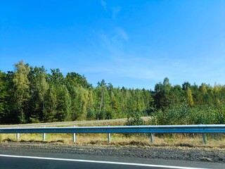 Country highway on a sunny spring day. Country asphalt regional road with marking lines. There is...