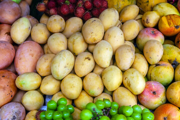Lots of different ripe fruits on the market in Asia. Fruity multicolored background.