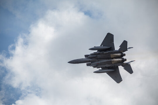 F15 fighter jet taking off from RAF Lakenheath with landing gear up, Image shows the underneath of the aircraft as the pilot climbs and performs a slight roll