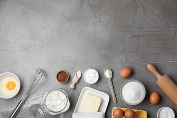 Baking powder and other products on grey textured table, flat lay. Space for text