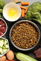 Dry pet food and natural products on grey table, top view