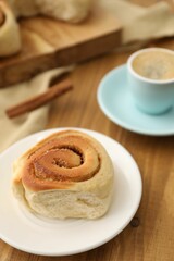 Freshly baked cinnamon roll on wooden table, closeup