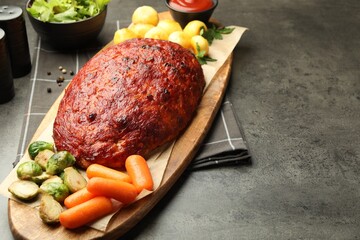 Delicious turkey meatloaf with vegetables on grey table, closeup. Space for text