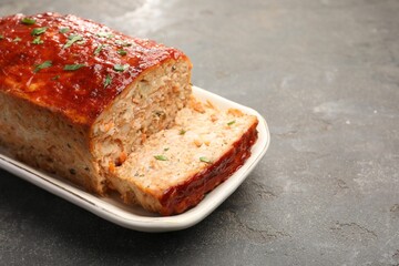 Delicious baked turkey meatloaf on grey table, closeup. Space for text