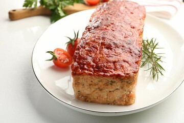 Delicious baked turkey meatloaf, rosemary and cherry tomatoes on white table, closeup