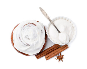 Tasty cinnamon roll with cream and spices isolated on white, top view