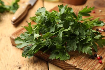 Fresh parsley and peppercorns on wooden table, closeup