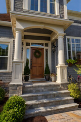 Elegant Home Exterior with Stone Steps and Classic Columns. This stunning house features a beautiful front porch and landscaping design, creating a welcoming entrance.