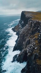 Dramatic coastal cliff, ocean waves crashing, moody sky, travel landscape